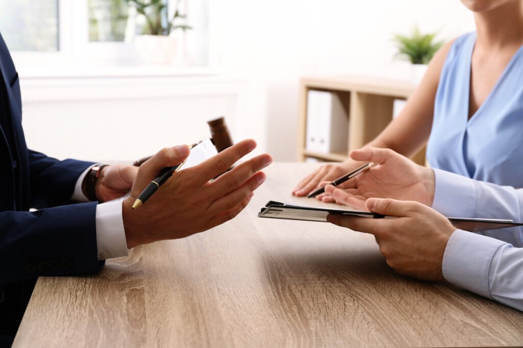 Lawyer working with clients at table in office, focus on hands